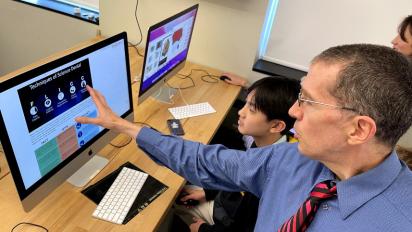Teacher pointing out science denial techniques to a student.