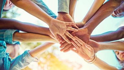 Hands together in a team huddle.