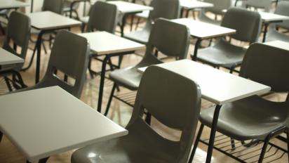 Rows of empty desks and chairs.