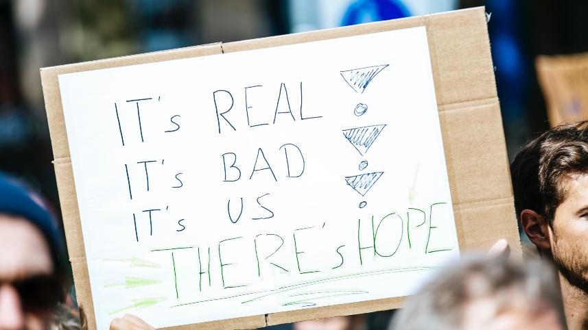 Sign that says, "It's Real, It's Bad, It's Us, There's Hope."