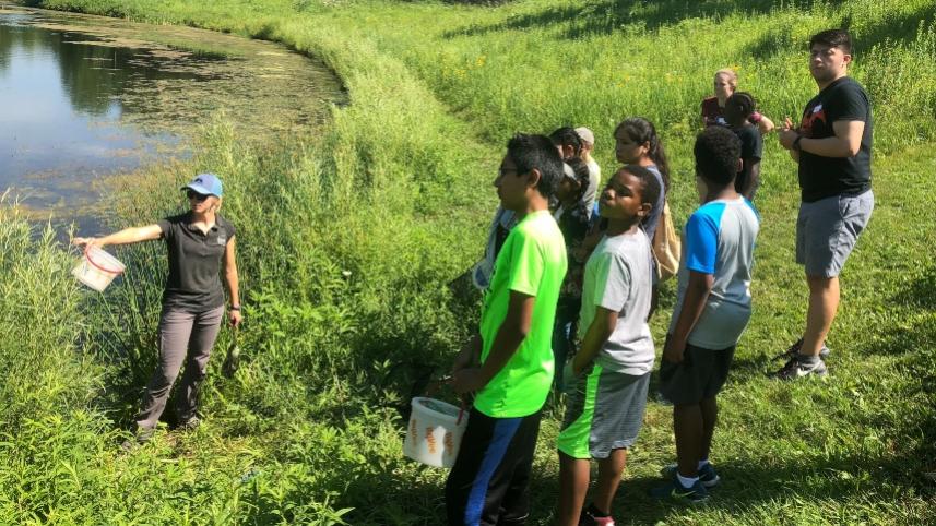 Teacher with students in the field